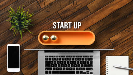 message START UP above a loading bar with office equipment on wooden backgroundの写真素材