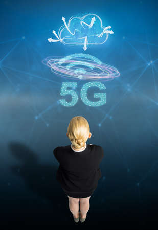 businesswoman with message 5G on abstract blue backgroundの写真素材