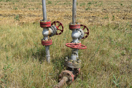 Oil valve with rocking in the background. The gate on an oil well