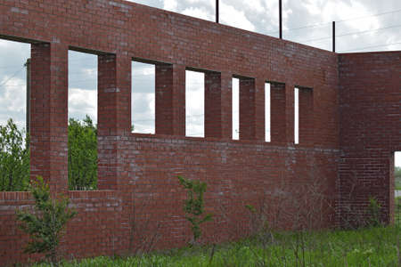 Abandoned building of red brick. The walls and windows of the unfinished home.の写真素材