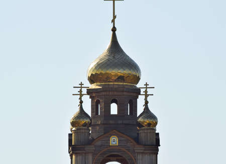 Domes of an Orthodox church. Gold-plated dome, orthodox crosses and blue roof.