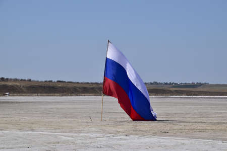 Russia, Veselovka - September 6, 2016: Russian flag on the bottom of a salty lake. Attributes...