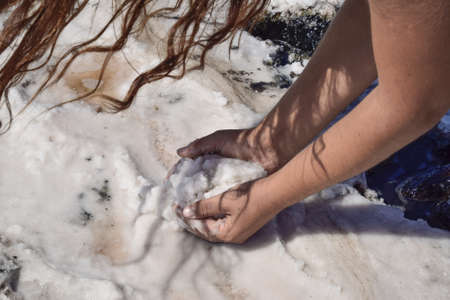 Hands girls taking on the wet salt from the puddles. Salt on the salt lake.の写真素材