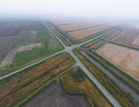 Crossroads paved roads through the fields. View from above.の写真素材