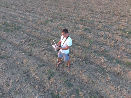 The man is holding a remote control from the quadrocopters. Photographer's work with gadgets.