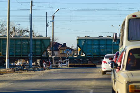 Poltava village, Russia - September 18, 2016: Waiting for passage of a freight train near railway crossing. Traffic jam.の写真素材