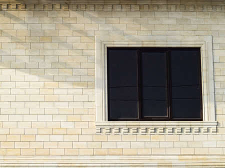 Background of yellow brick and windows. Wall of yellow bricks with a plastic window. The texture of the wall.の写真素材