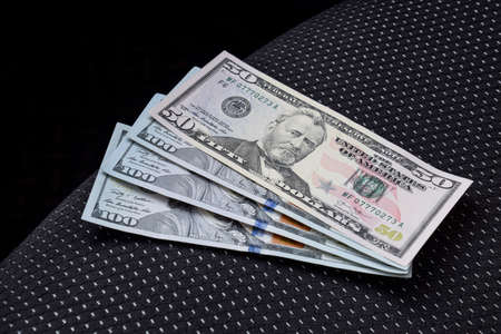 Several banknotes American dollars lie on the car seat. The money in the car.の写真素材