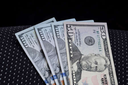 Several banknotes American dollars lie on the car seat. The money in the car.の写真素材