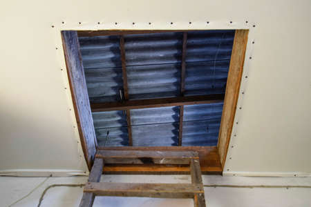 Open the entrance to the attic. The staircase and the door to the attic of the house.の写真素材