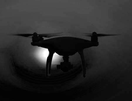 Quadrocopters silhouette against the background of the sunset. Flying drones in the evening sky.の写真素材