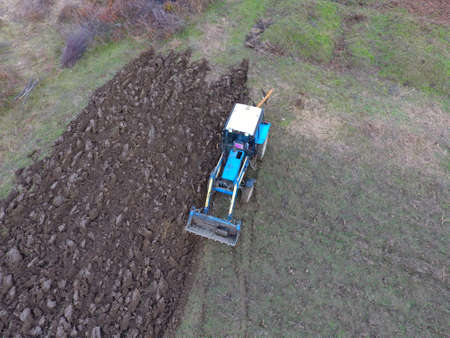 Tractor plowing the garden. Plowing the soil in the garden.の写真素材