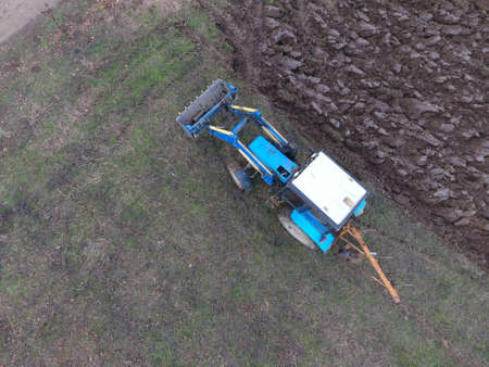 Tractor plowing the garden. Plowing the soil in the garden.の写真素材