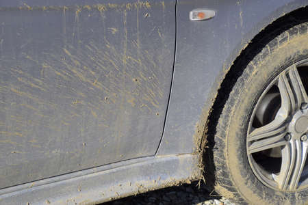 The mud on the wheels, fenders and car doors. The result is a trip through the mud. Dirty car.の写真素材