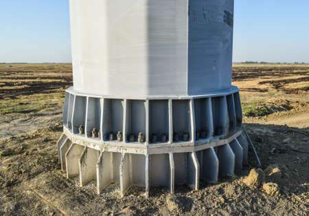 The base of the column power line support. Massive metal pole.