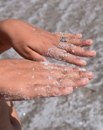 Salt on the girl's hands. Dried salt on the hands of women of the ancient lake.