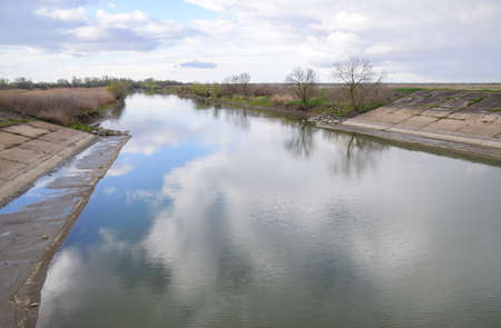 Paved concrete banks of the irrigation canal at the outlet of the water pumping station.