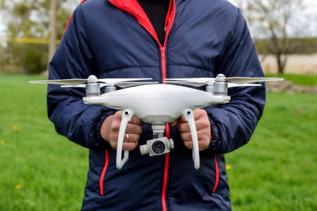 Krasnodar, Russia - May 15, 2017: A man with a quadrocopter in his hands. A white drone is being prepared for the flight. Phantomのeditorial素材