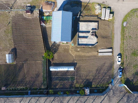Buildings on the site. Hangar from metal profile, corrugated. The foundation of the houseの写真素材
