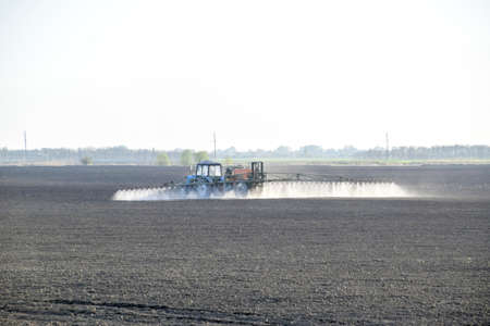 The tractor sprayed herbicides on the field. Chemistry in agriculture.