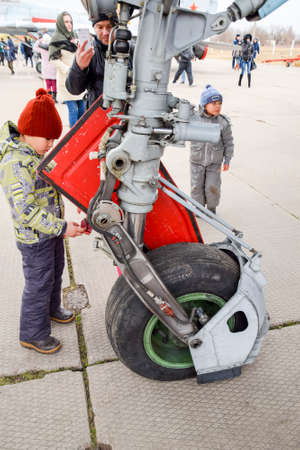 Krasnodar, Russia - February 23, 2017: Chassis of a military aircraft. Child at the wheel of the chassis. Su-35 fighter at the air show. Aircraft on the airfield to show the audience.のeditorial素材