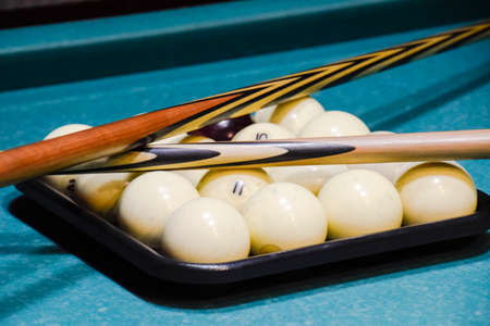 Billiards, billiard table, balls and cue. Balls in the tray and two cues on the balls.の写真素材