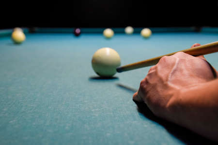 Billiards, billiard table. Targeting the cue in the ball for impact.