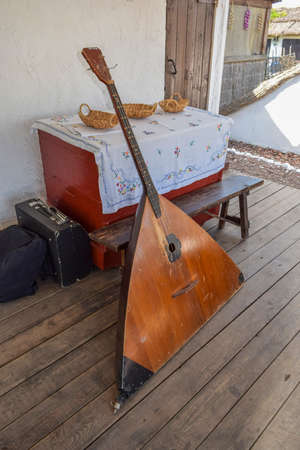 Balalaika-contrabass under a canopy in a cottage. Bass balalaika rare instrument.の写真素材