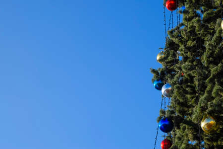 Tinsel and toys, balls and other decorations on the Christmas Christmas tree standing in the open air. Decorations New Year tree.の写真素材