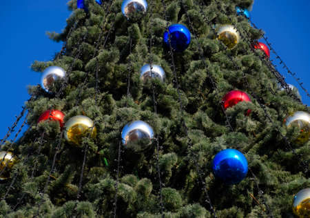 Tinsel and toys, balls and other decorations on the Christmas Christmas tree standing in the open air. Decorations New Year tree.の写真素材