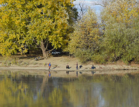 Krasnodar, Russia - November 4, 2017: Fishermen on the river bank. Autumn scenery of the river bank. Yellow leaves of poplars. Autumn fishing.のeditorial素材