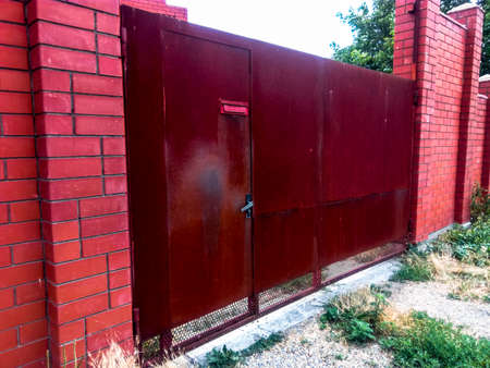 Steel rusty gates and a red brick fenceの写真素材