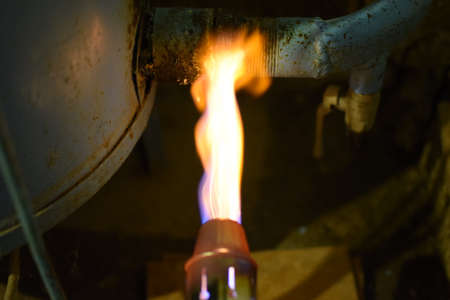 Heating a steel pipe with a blowtorch. The flame of a blowtorch.