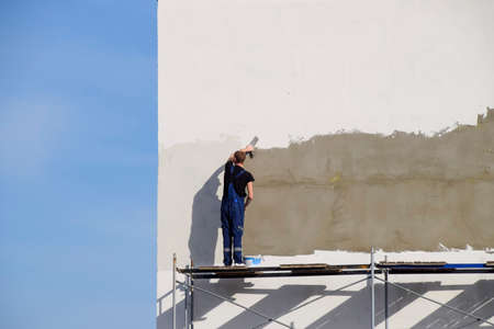 Slavyansk-na-Kubani, Russia - September 9, 2016: Plasterers Builders plastered wall in a commercial building. Work on scaffolding.のeditorial素材