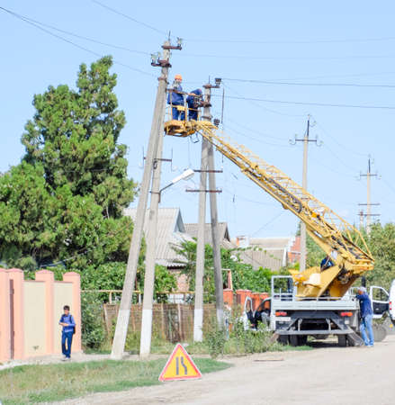 Slavyansk-on-Kuban, Russia - September 7, 2017: Electricians repair the power line with a lift. Repair work. Current repair of electrical wiring.のeditorial素材
