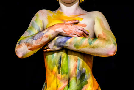 Body art. Drawing on the body. Beautiful girl with painted body watercolors. A white young girl painted the body with paint.の写真素材