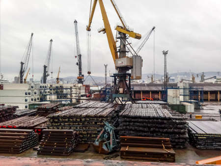 Novorossiysk, Russia - August 20, 2017: The metal rods folded on the port site for export. Temporary storage in the port of raw materials. Port cargo and cranes.のeditorial素材
