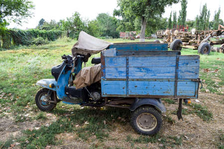 Scooter ant. Old Soviet motor scooter on three wheels with a cart. Soviet cargo tricycle scooter...