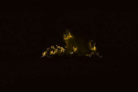 Yellow flame. Fire. Burning of rice straw at night.