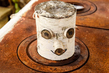 Toy souvenir from a birch log. eyes nose and mouth are made on a birch logの写真素材