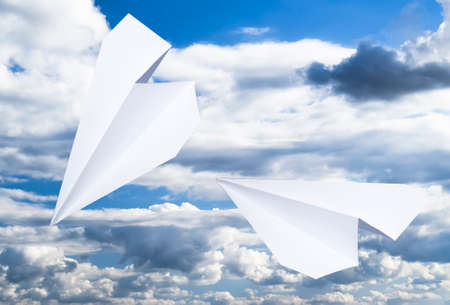 White paper airplane in a blue sky with clouds. The message symbol in the messenger.の写真素材