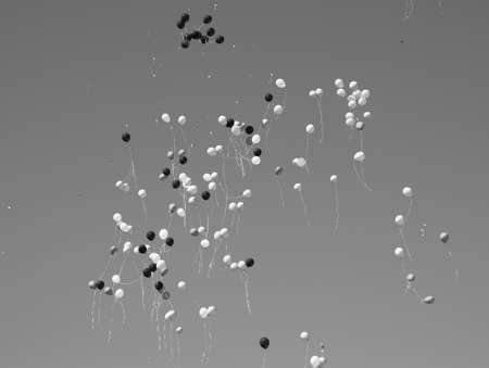 Multicolored balls, filled with helium, fly in the blue sky.の写真素材