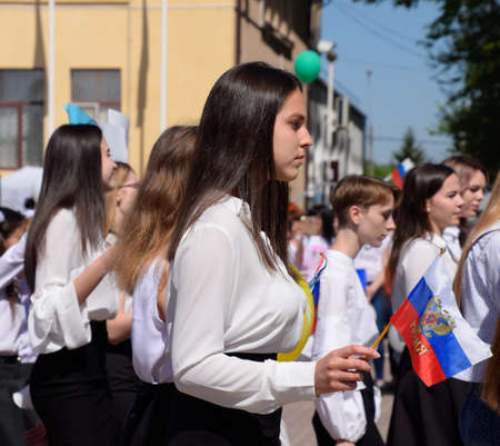 Slavyansk-on-Kuban, Russia - May 1, 2018: Girl with the flag of Russia. Celebrating the first of May, the day of spring and work. May Day parade on the Theater Square in the city of Slavyansk-on-Kuban.のeditorial素材