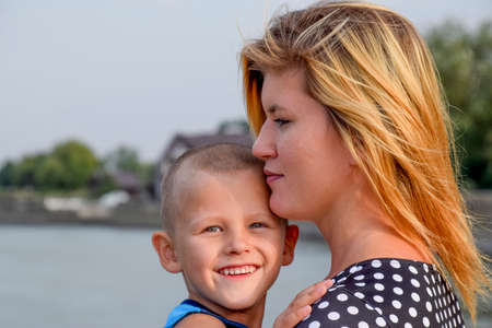 Mother with her son in her arms. Mother presses her child to her.の写真素材