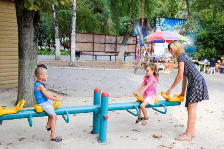 Krasnodar, Russia - August 28, 2017: A young mother plays with the children on the playground.のeditorial素材