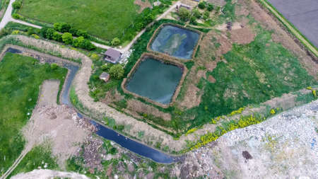 Purification facilities, sewage treatment pools. Landfill of garbage outside the village.の写真素材