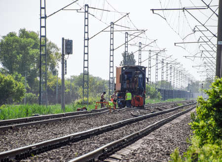 Staronozhesteblyevskaya, Russia - May 5, 2018: Workers repair the rails on the railway. Railway track. Repair work.のeditorial素材