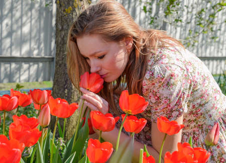 Girl sniffing tulips. The girl among the flowersの写真素材