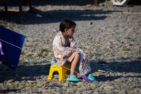 Novorossiysk, Russia - August 06, 2018: The girl sits on a chair near a tent wrapped in a blanket.のeditorial素材