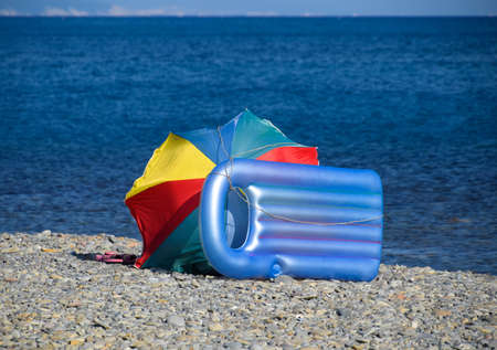 Inflatable mattress and sun umbrella on the beach.の写真素材
